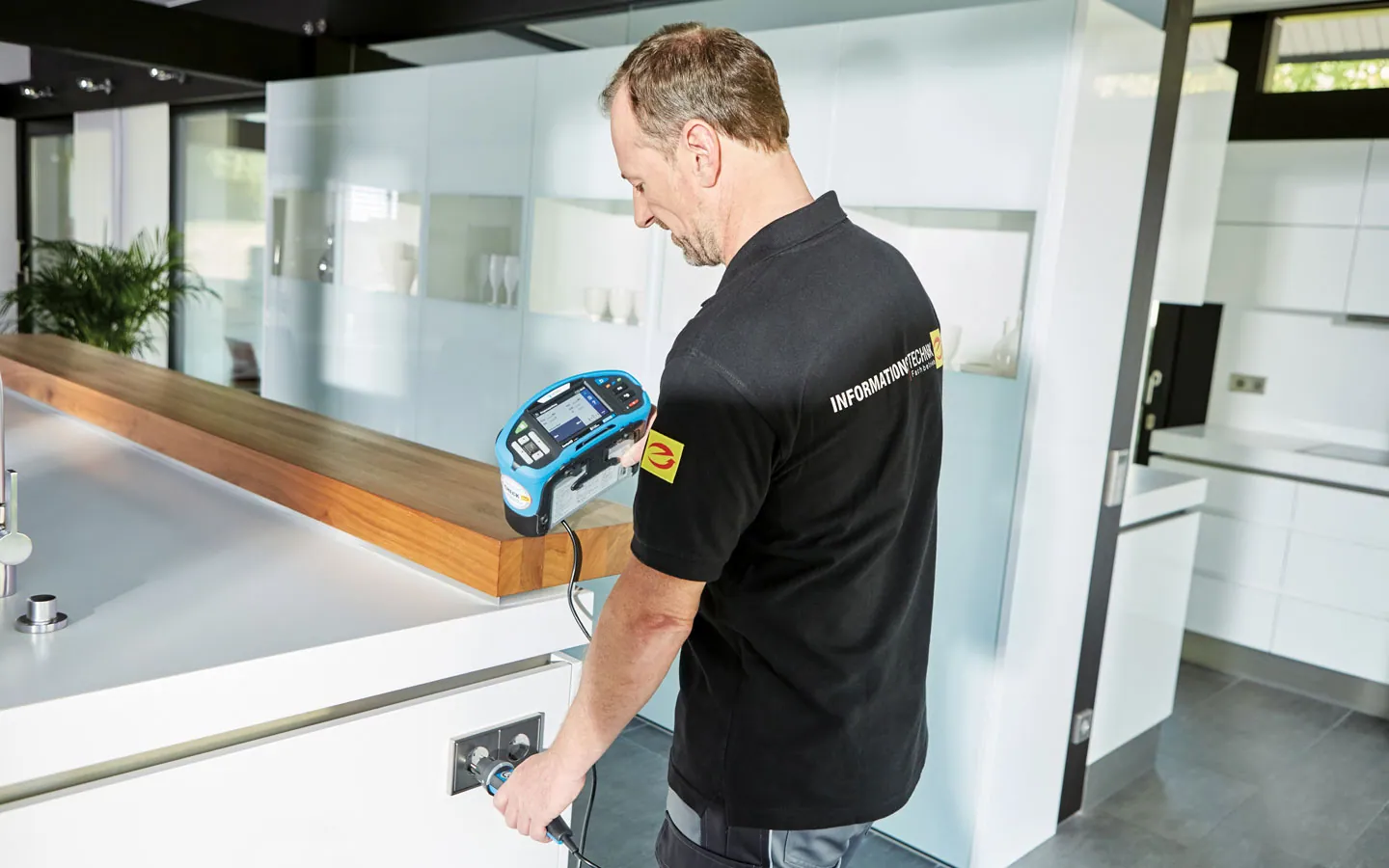 E-CHECK - Mitarbeiter prüft die Steckdosen in der Küche &middot; Elektro Roth
